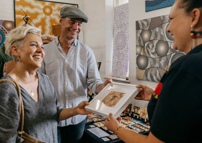 Couple looks at the Aboriginal artwork for sale at the Yaingayaingarra stand at the Blak Markets, Bare Island, La Perouse